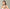 Woman holding a bottle of Ayurvedic skincare product against a plain background at shopayurveda.eu