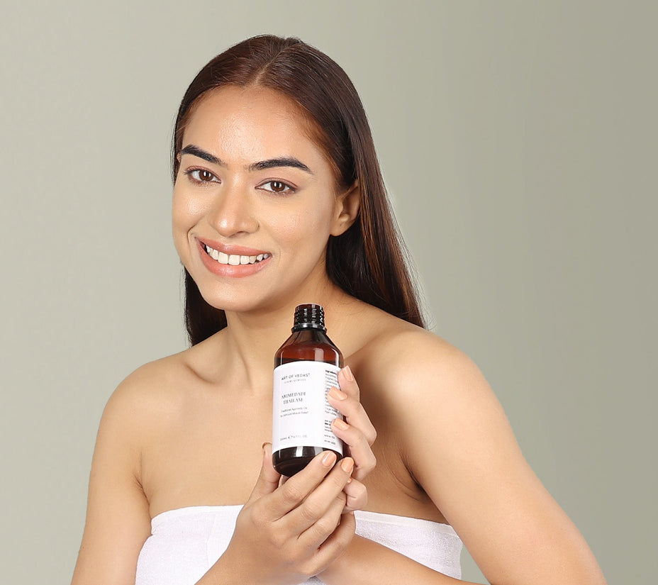 Woman holding a bottle of Ayurvedic skincare product against a plain background at shopayurveda.eu